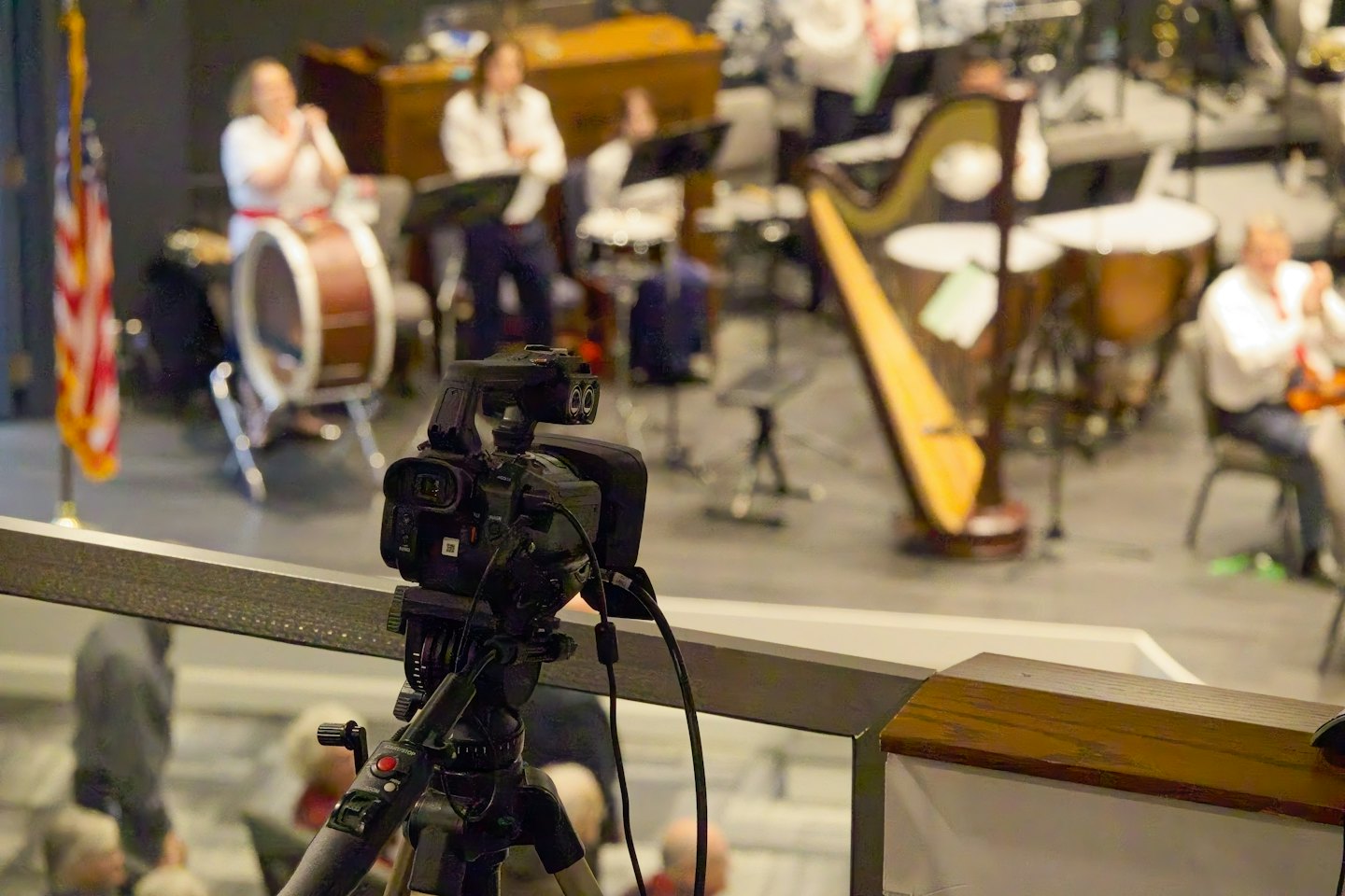 Una videocamera professionale su un treppiede registra un'esibizione musicale dal vivo.