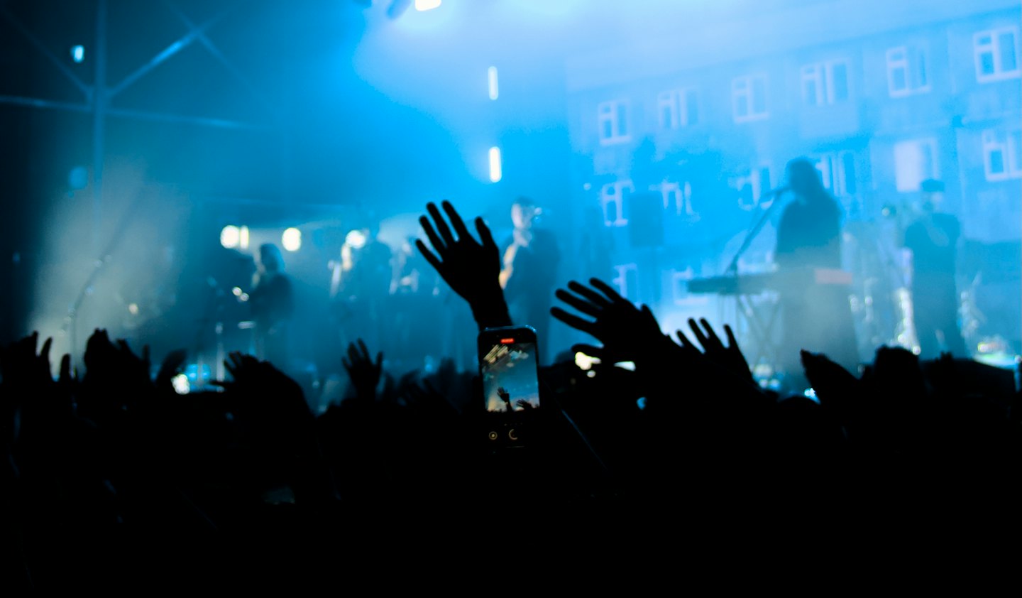 La folla alza le mani a un concerto dal vivo.